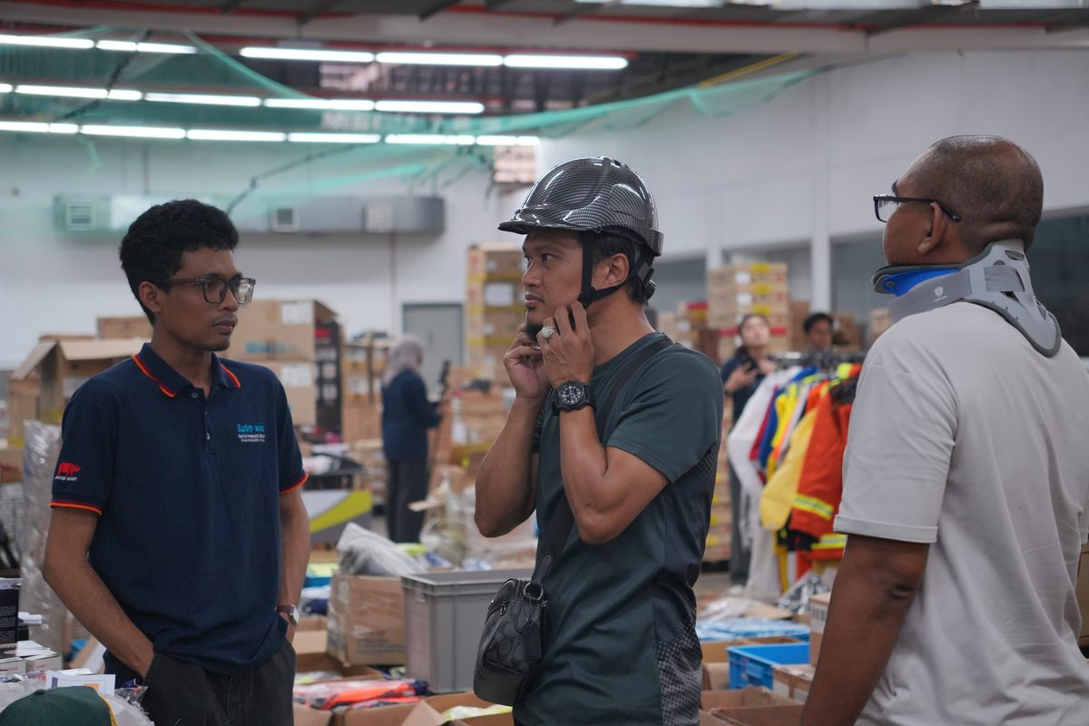 Visitor trying on a safety helmet at Safetyware HQ during Warehouse Sale Day 1