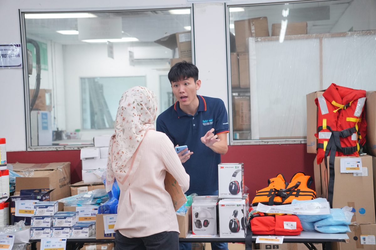 Safetyware staff member speaking with a visitor at the warehouse sale